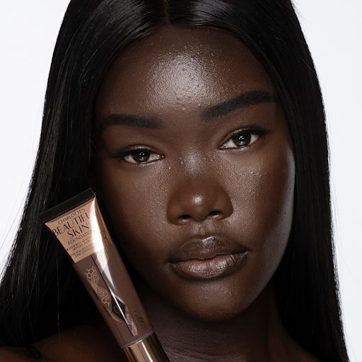 Beautiful Skin Foundation in 17N on a deep-tone model Deep-tone brunette model with brown eyes wearing nude pink lipstick with a skin-like foundation with a flawless, dewy finish.