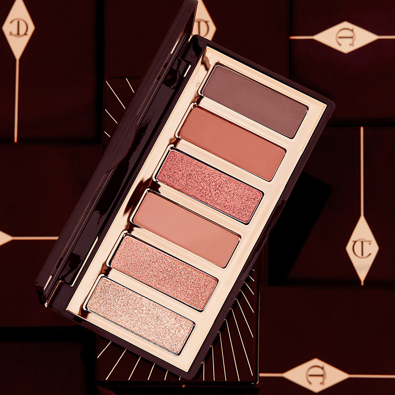 An open eyeshadow palette with six, shimmery and matte eyeshadows in bronze, pink, terracotta and brown.
