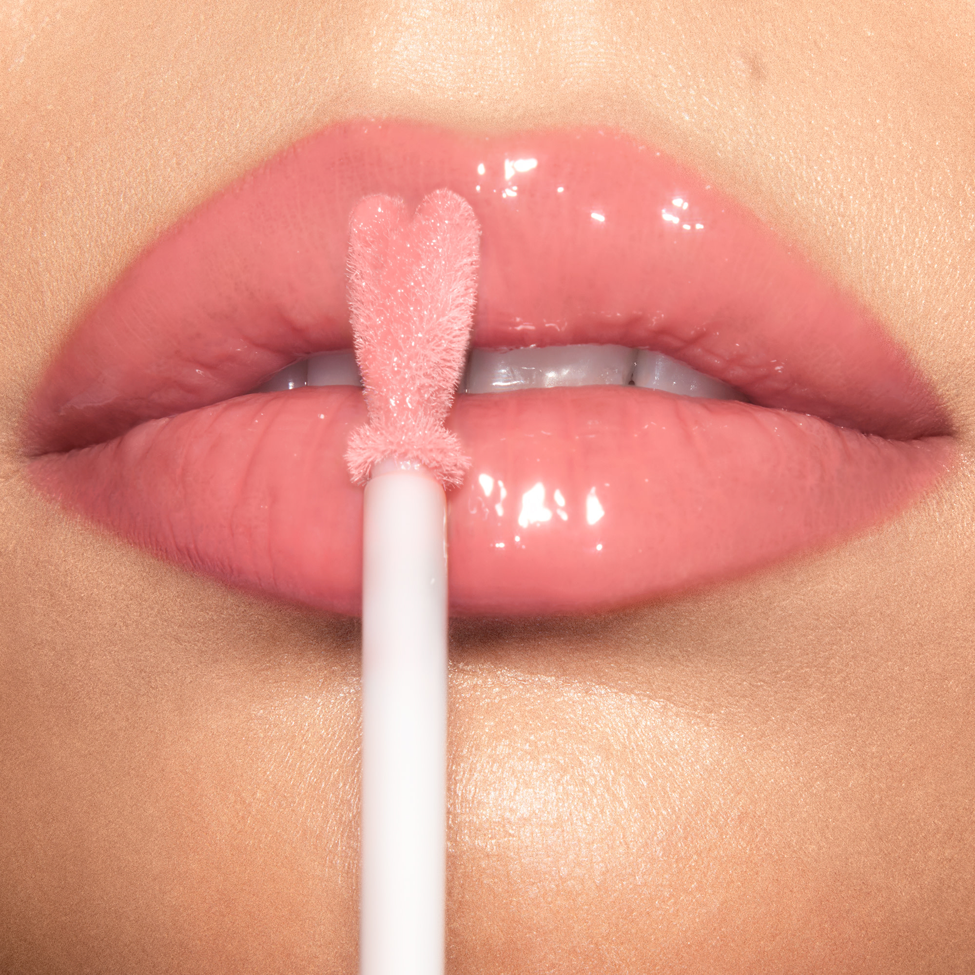 Model close up applying Collagen Lip Bath lip gloss
