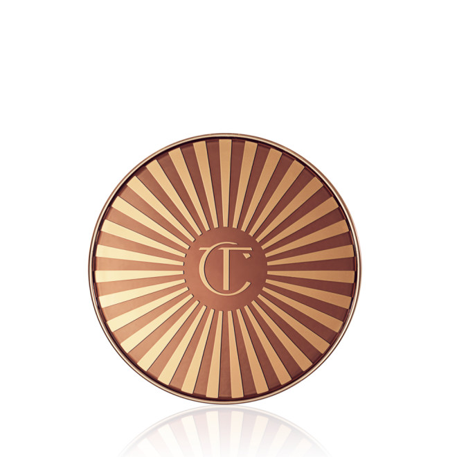 Closed bronzer compact with a golden and brown-coloured lid with the printed logo engraved in the middle. 