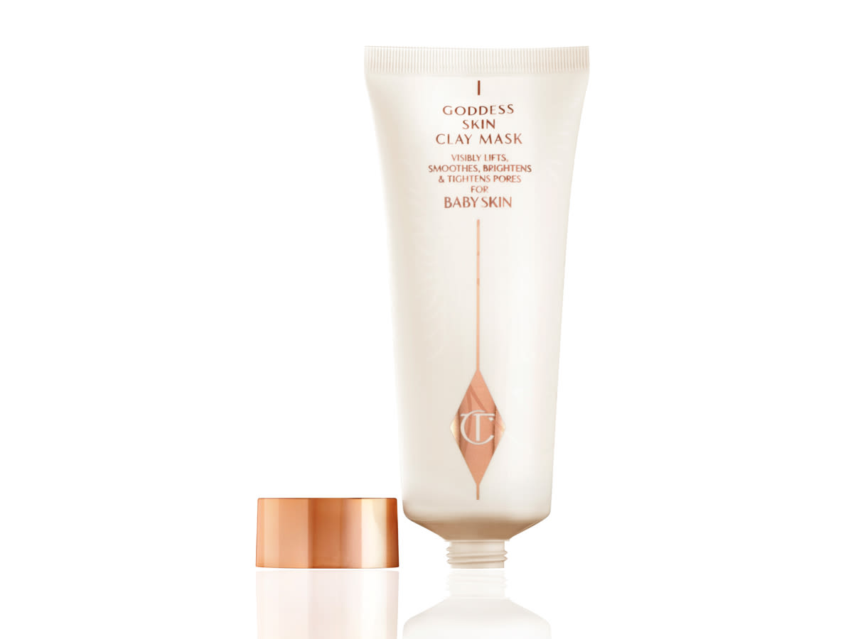 Goddess Skin Clay Mask lid off A clay mask in a shiny, ivory-coloured bottle with rose-gold coloured text on it and its rose-gold-coloured lid next to it.