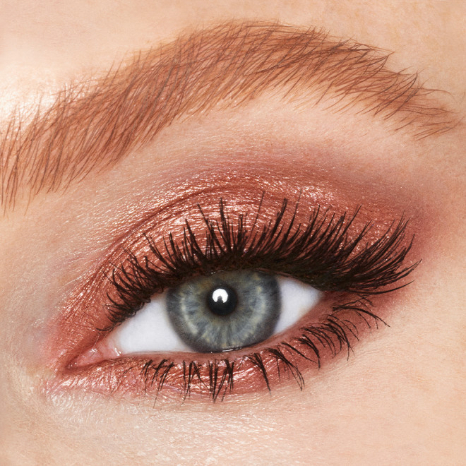 Single-eye close-up of a single blue eye with shimmery, coppery-gold-coloured cream eyeshadow. 