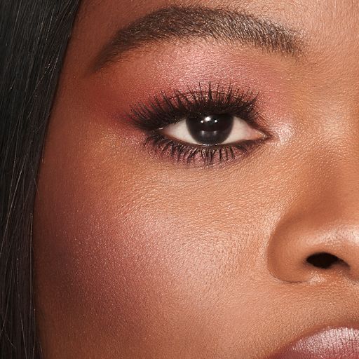 Cheek To Chic in Walk of No Shame on deep-tone model A deep-tone model with brown eyes with a soft and glowy berry-pink blush with gold shimmer.