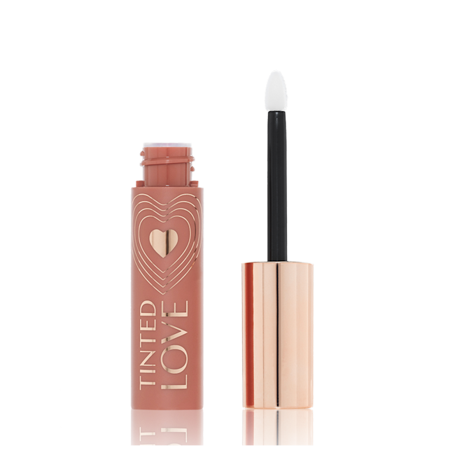 Tinted Love Lip and Cheek Tint in Blushed Rose lid removed An open tube of lip and cheek tint in a sheer, tea rose colour with a gold-coloured lid and doe-foot applicator.
