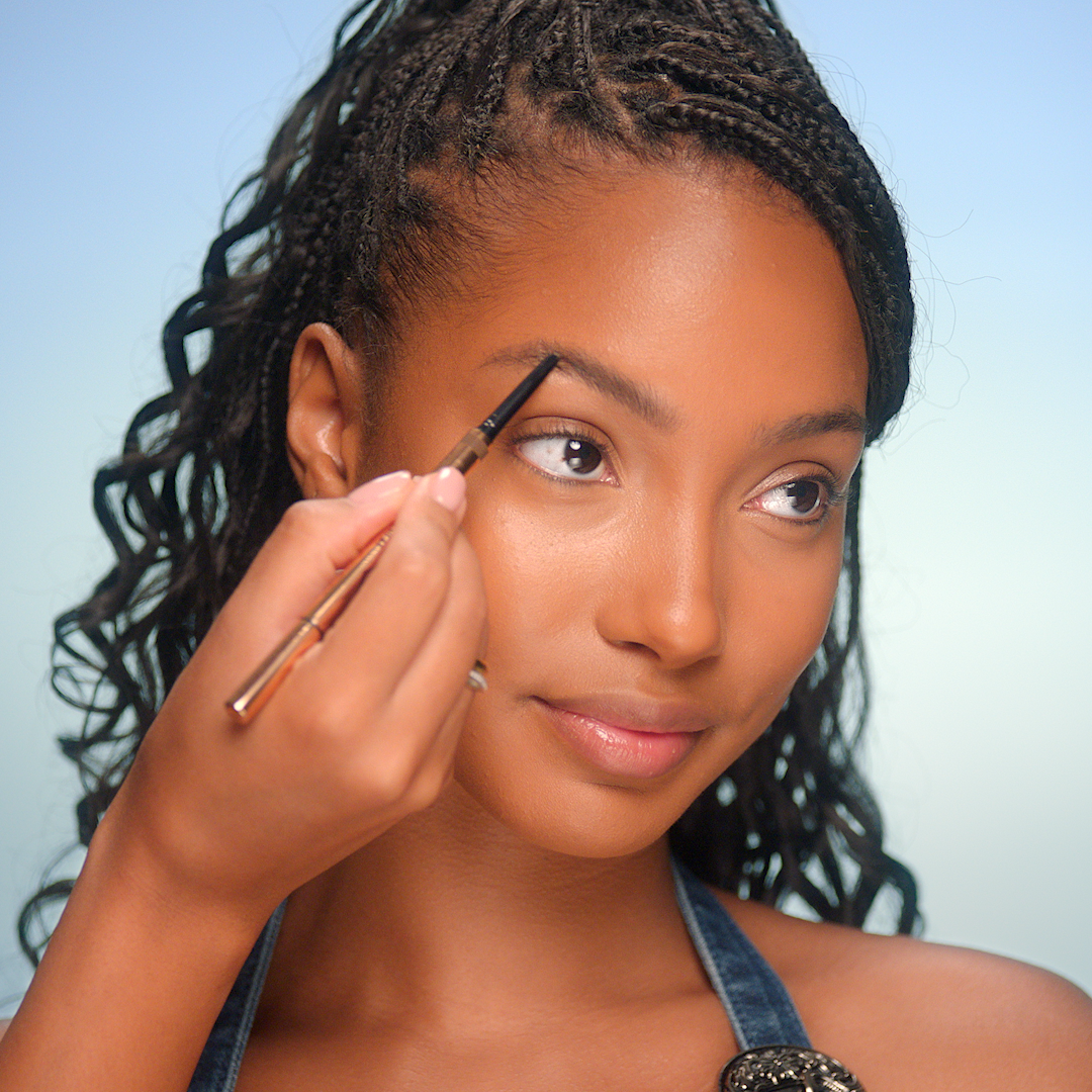 2000s makeup tutorial step 5 thin eyebrows Model having eyebrow pencil applied to create a thin 2000s look
