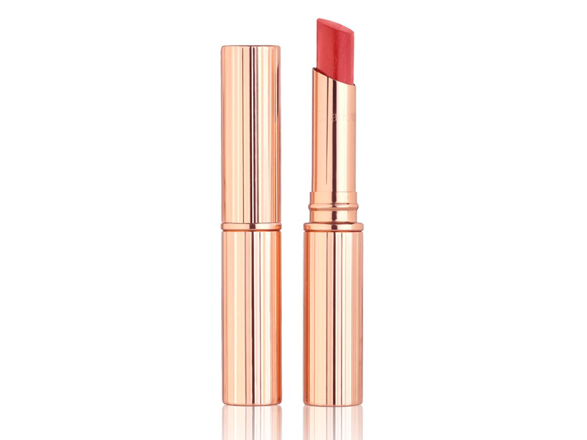 Superstar Lips in Happy Lips, with and without lid Two lip balm lipsticks, with and without lid in a dark orange-red shade.