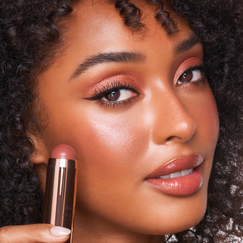 Beach Sticks model shot Model holding Beach Sticks cream blush stick in Formentera