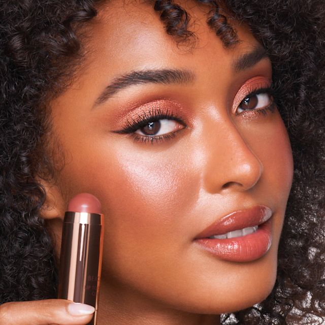 Beach Sticks model shot Model holding Beach Sticks cream blush stick in Formentera