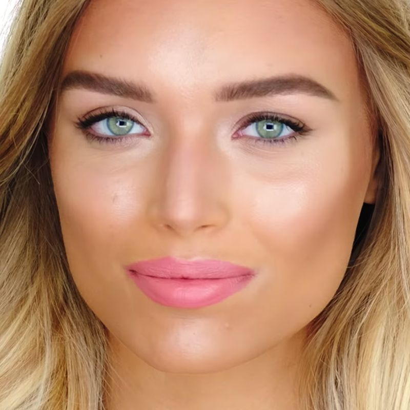 Close-up of a light-tone blonde model wearing a bright pink, matte liquid lipstick. 
