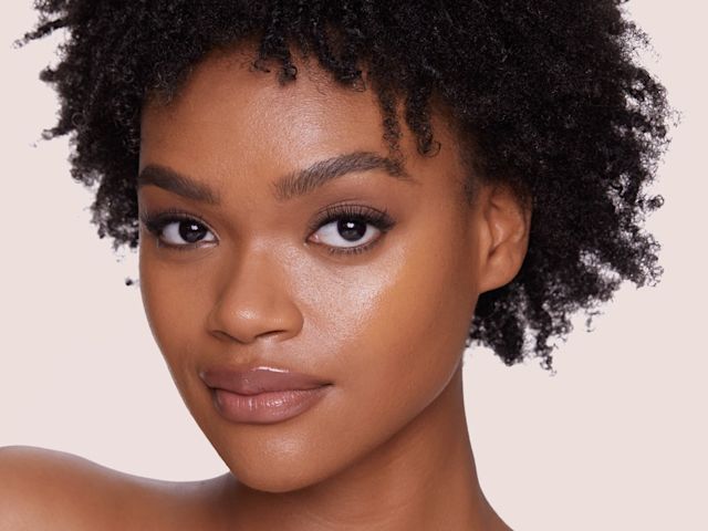Airbrush Flawless Foundation in Shade 3 Tan on deep-tone model Deep-tone brunette model wearing glowy foundation in a dark brown shade that covers her pores and makes her skin look flawless and youthful.