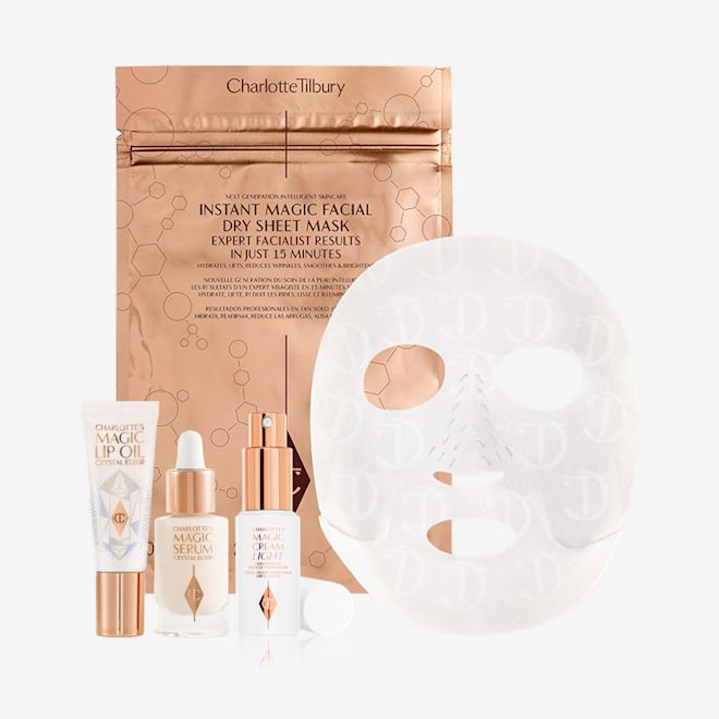 Hydrate Glow Summer Skin Secrets bundle displayed Lip oil in a white-coloured tube, travel-size luminous facial serum in a glass bottle with a dropper lid, travel-size face cream in a white bottle with a pump dispenser, and sheet mask in gold foil packaging.