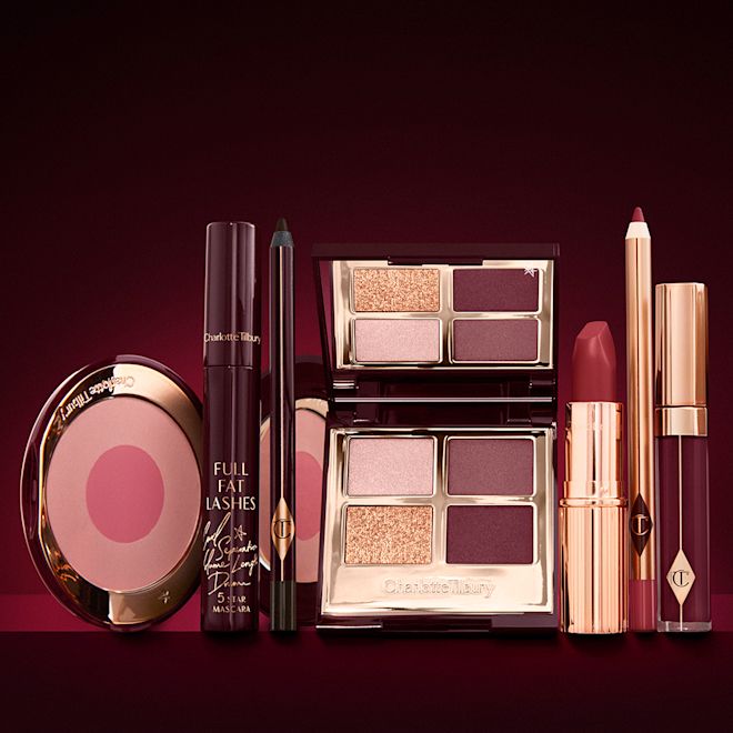 The Vintage Vamp kit for fair-tone open An open, mirrored-lid eyeshadow palette in matte and shimmery gold and red shades, an open black eyeliner pencil, a mascara in a dark-crimson colour scheme, a red lipstick with a matching lip liner pencil, vampy-red lip gloss, and an open two-tone blush in cool pink.