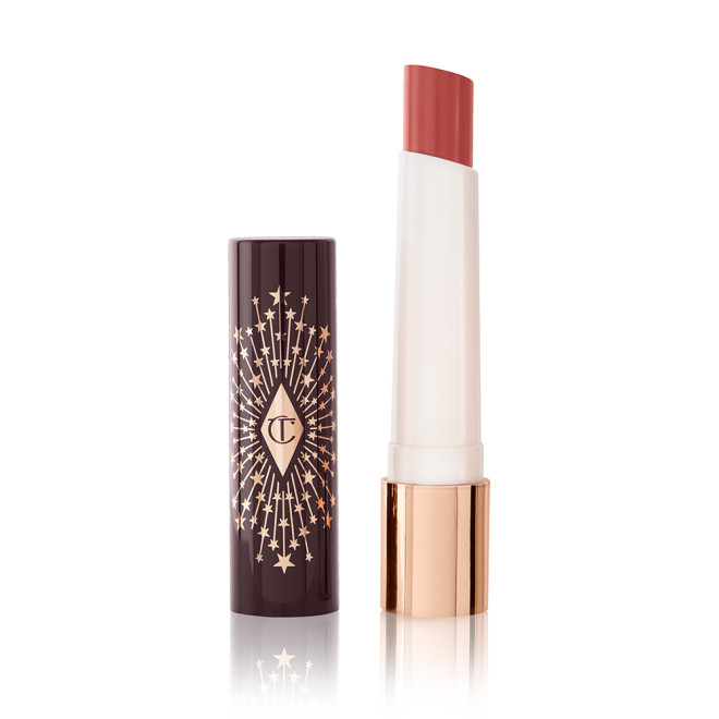An open, moisturizing lipstick lip balm in a dark peachy-brown shade with a black and gold-coloured cover. 