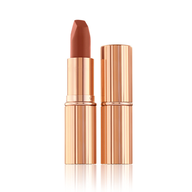 Two lipsticks, with and without lid, in a deep, sultry rose-brown nude matte shade, in sleek, gold-coloured tubes. 
