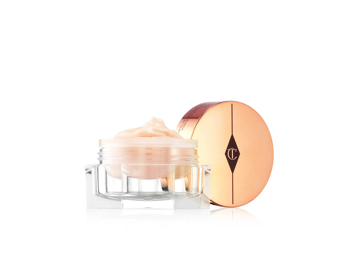 Magic Eye Rescue open An open, light champagne-coloured eye cream in a glass pot with its rose-gold-coloured lid next to it.