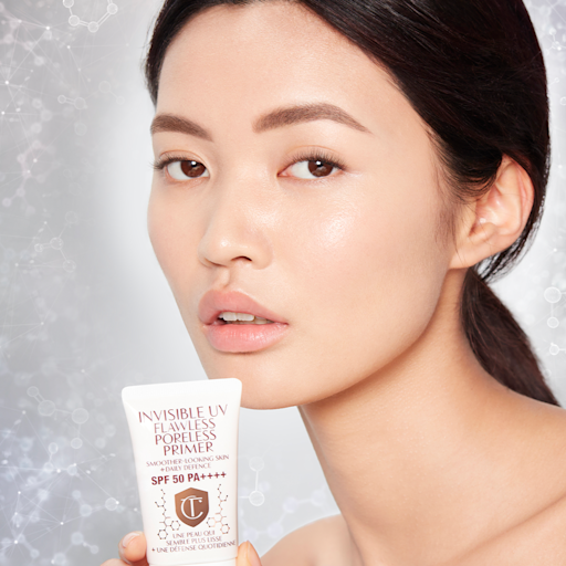 Invisible UV Flawless Poreless Primer on fair-tone model Fair-tone brunette model with brown eyes and glowy, smooth skin wearing a primer that makes her skin look flawless and glass-like.