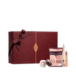Pillow Talk Romance Box with Sleeve displayed An open, mirrored-lid quad eyeshadow palette in matte and shimmery shades of pink and gold, an open matte lipstick in a nude pink shade, and crema eyeshadow in a glass pot with a dark brown lid, along with a white and scarlet makeup sleeve.