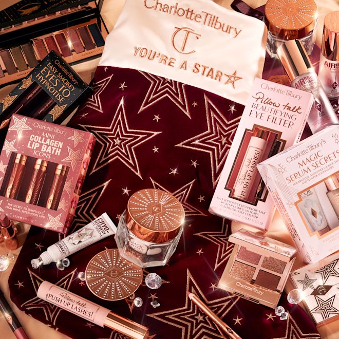 Holiday Stocking fillers banner Banner with a collection of lip kits, travel-size moisturisers, mascaras, quad eyeshadow palettes, eye mask, and other skincare items that would make for great stocking fillers.