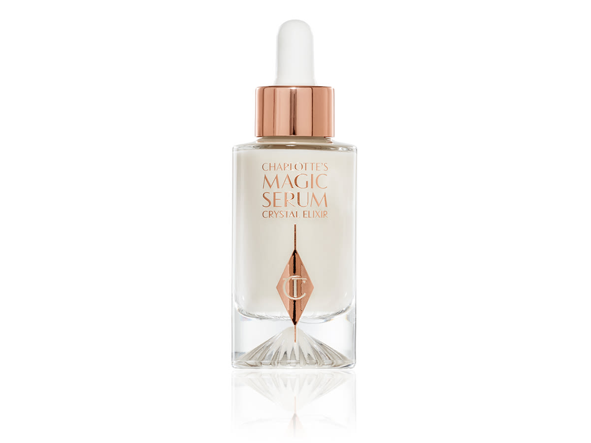 Charlotte's Magic Serum Crystal Elixir closed An open luminous, ivory-coloured serum in an opened glass bottle.