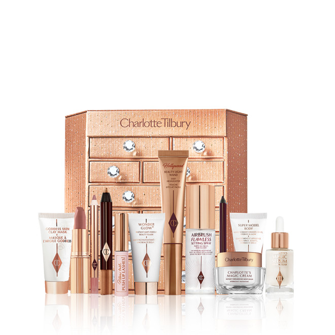 A golden-coloured chest of drawers with a clay mask, nude pink matte lipstick, nude pink lip liner, eyeliner pencil in dark copper, black-coloured mascara, liquid primer, champagne-coloured liquid highlighter, dark brown eyeliner pencil, pearly-white face cream, luminous ivory-coloured serum, and bronze-coloured body highlighter. 