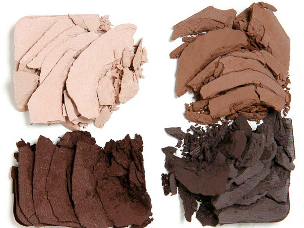 The Sophisticate palette swatches Swatches of four eyeshadows in shades of cream, light brown dark brown, and grey-brown.