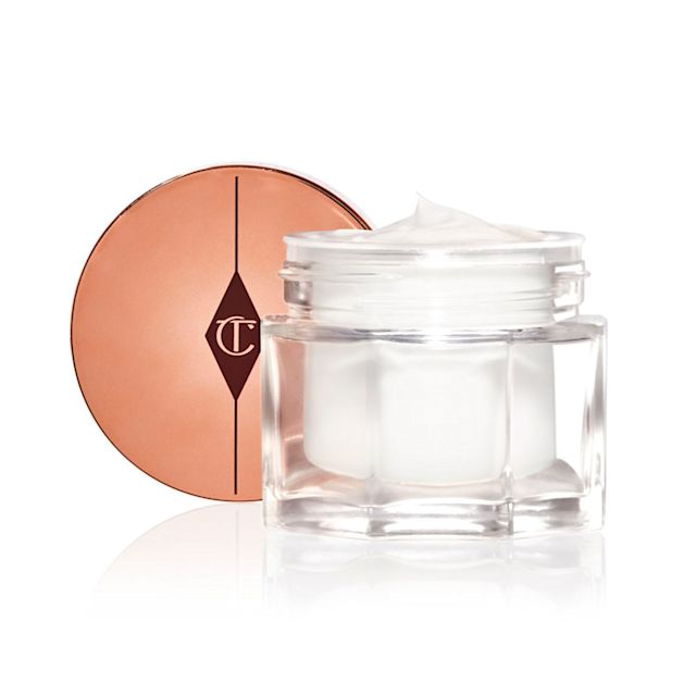 Magic Cream Packshot für den Blog Reichhaltige und hochwertige perlweiße Feuchtigkeitscreme in einem offenen Glastiegel mit goldfarbenem Verschlussdeckel dahinter.