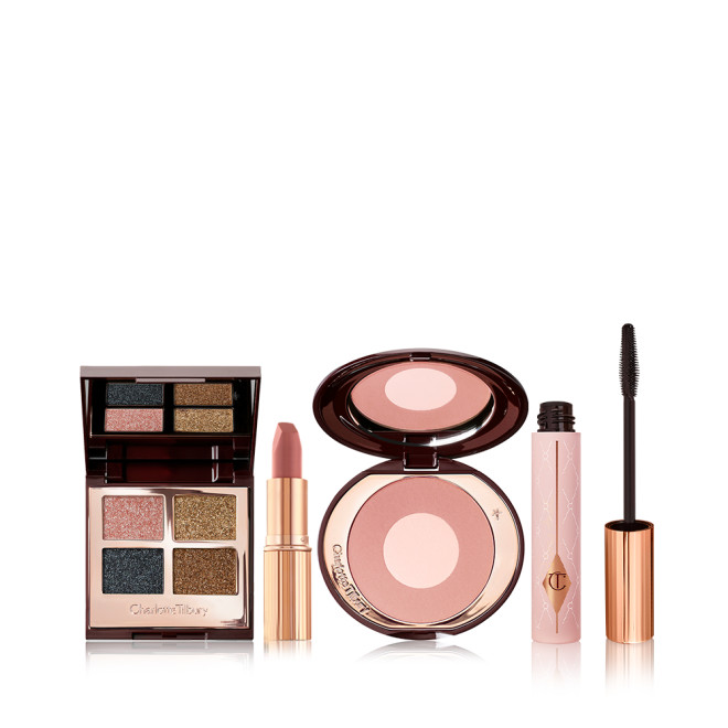 Open, quad eyeshadow palette with a mirrored-lid with shimmery shades of teal, rose gold, bronze, and dark brown, nude pink matte lipstick, two-tone blush compact in rose gold and champagne, black mascara in a nude pink bottle with a gold and black-coloured applicator.