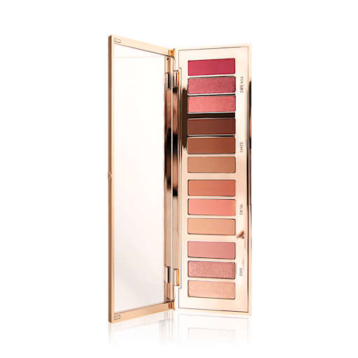 Instant Eye Palette in Pillow Talk lid opened An eye palette with a rose gold, high shine finish with its lid opened, revealing twelve eyeshadows in shades of pink, peach, brown, and champagne.