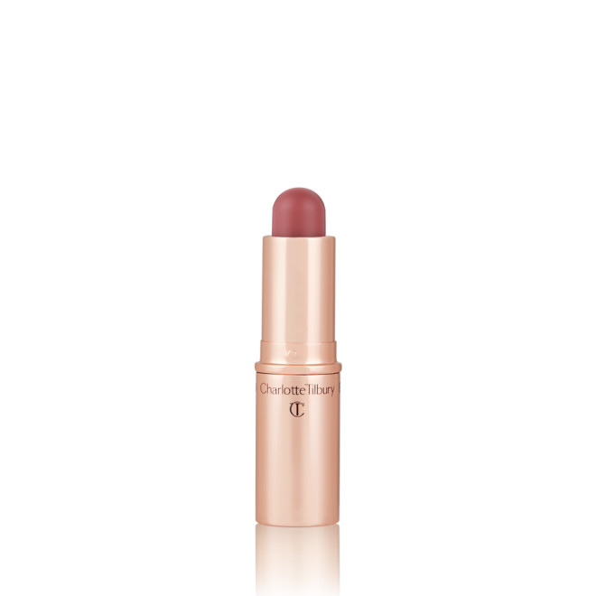 An open, lip and cheek colour stick in a glowy coral shade in a golden-coloured tube.