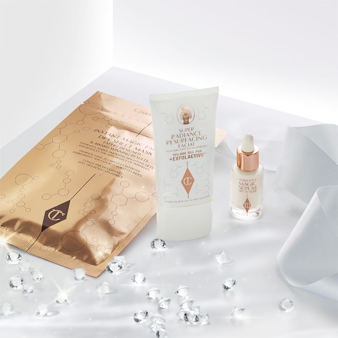 Magic Spa Facial Secrets displayed An exfoliating, wash-off mask in a white-coloured tube with a travel-size bottle of luminous face serum with a dropper lid, and a face mask in rose-gold-coloured foil packaging.