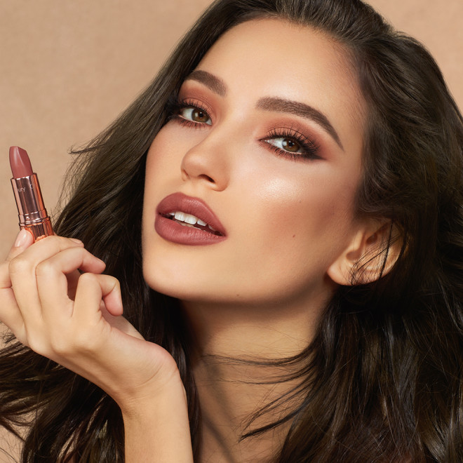 Medium-tone model with brown eyes wearing smokey brown eyeshadow with a deep, sultry rose-brown nude lipstick with a matte finish.
