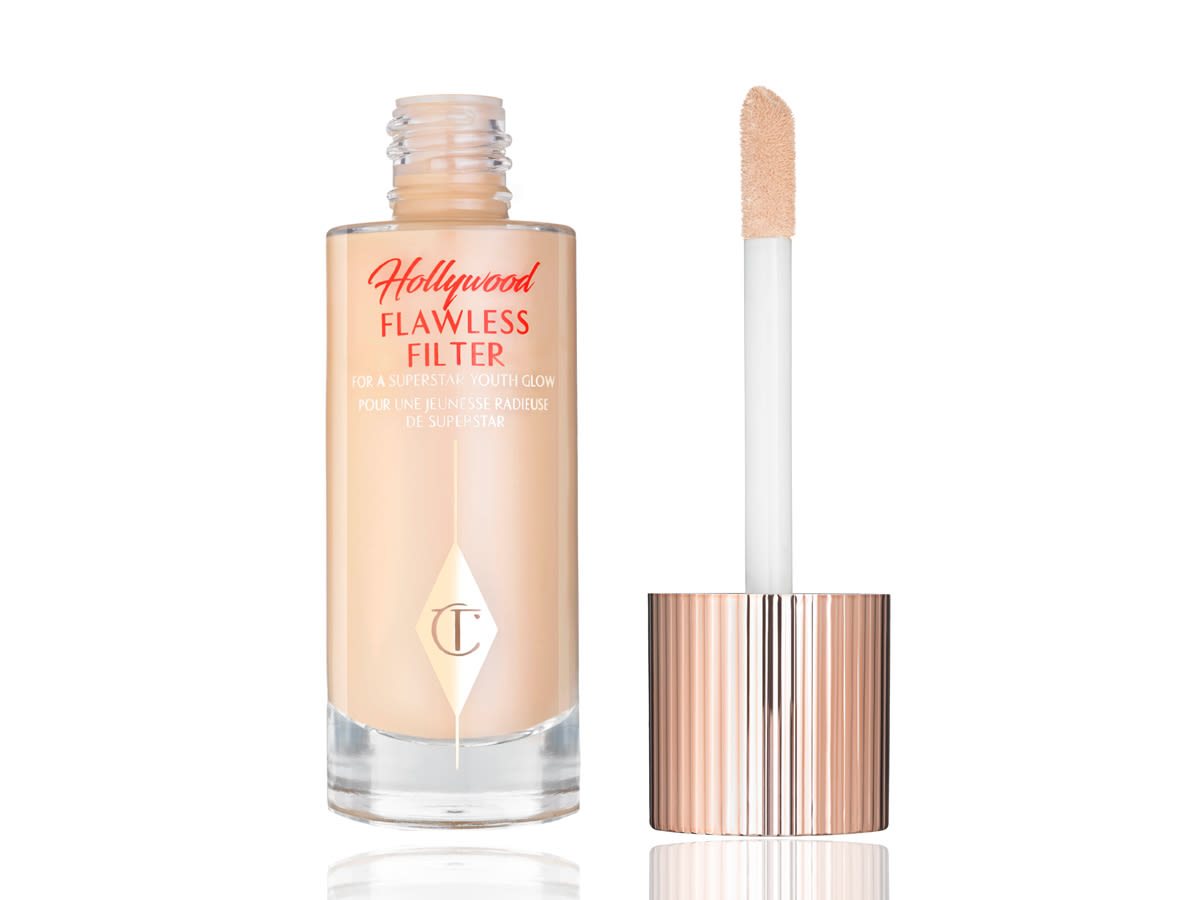 Hollywood Flawless Filter lid removed A glow-booting serum-primer in a clear, glass bottle with its doe-foot applicator lid next to it.