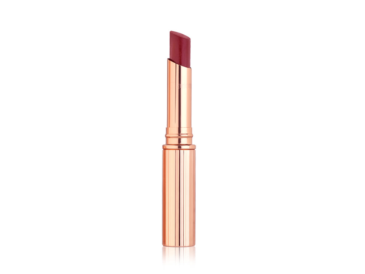 Superstar Lips in Walk of No Shame open An open, berry rose glossy lipstick in metallic, golden-coloured packaging.