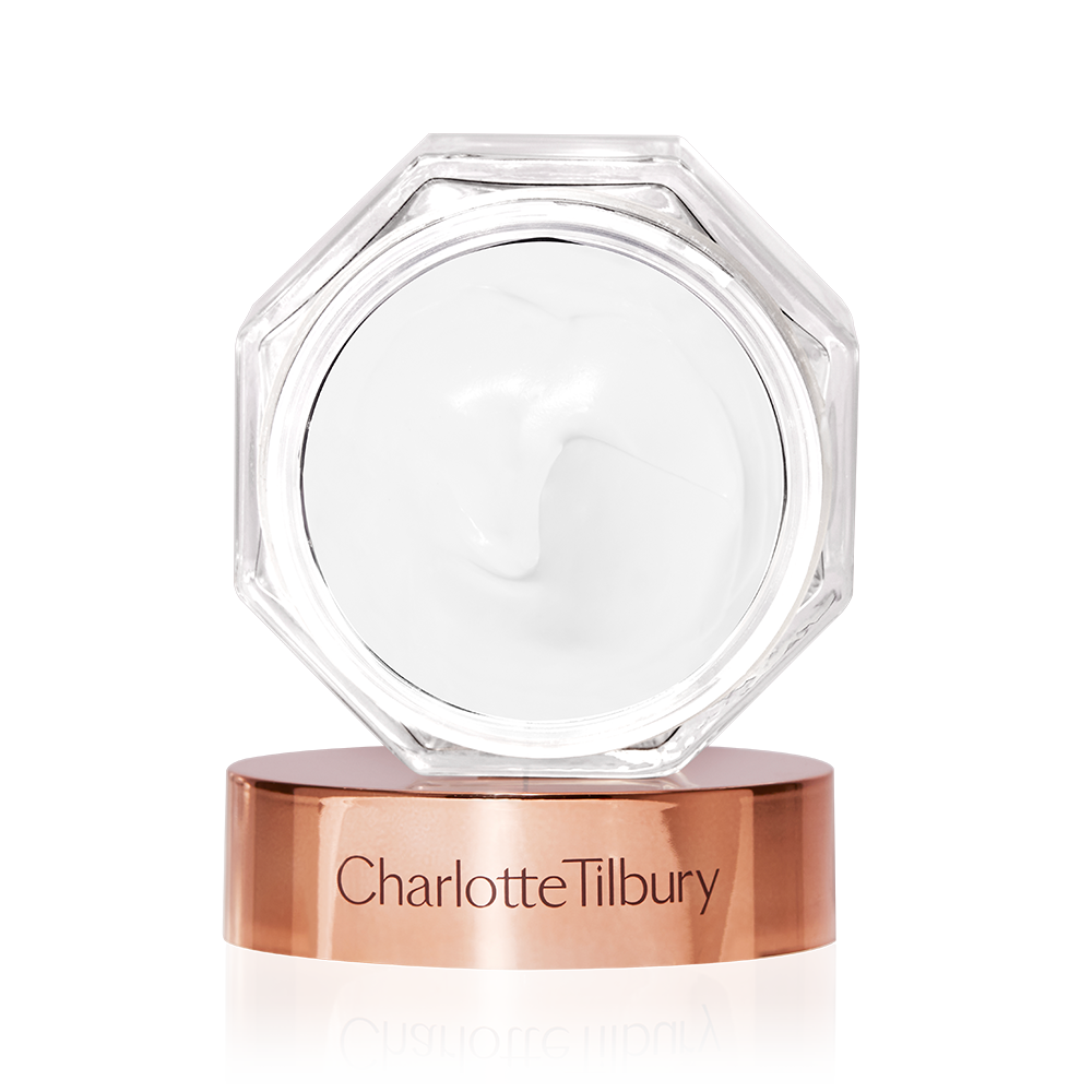 Magic Cream lid removed Thick, pearly-white cream in an open glass jar with its rose-gold-coloured lid next to it.