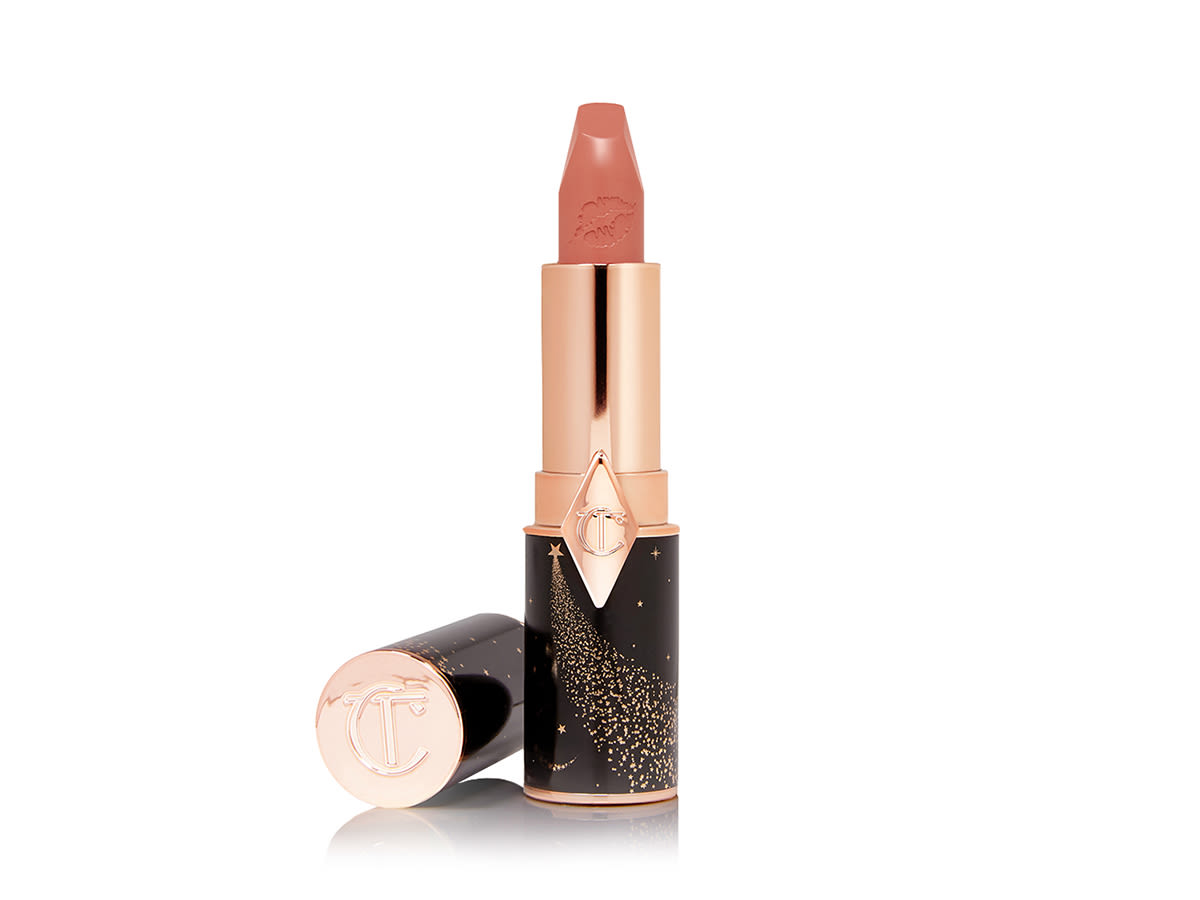 Hot Lips 2 in JK Magic open An open lipstick in a peachy nude-rose shade with a satin finish with its lid next to it.