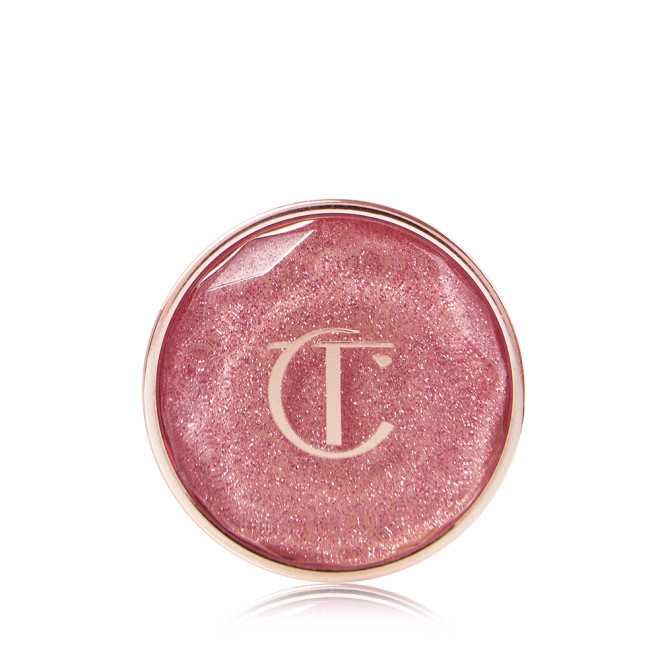 A nude pink shimmery eyeshadow pigment in a glass pot with a translucent lid. 
