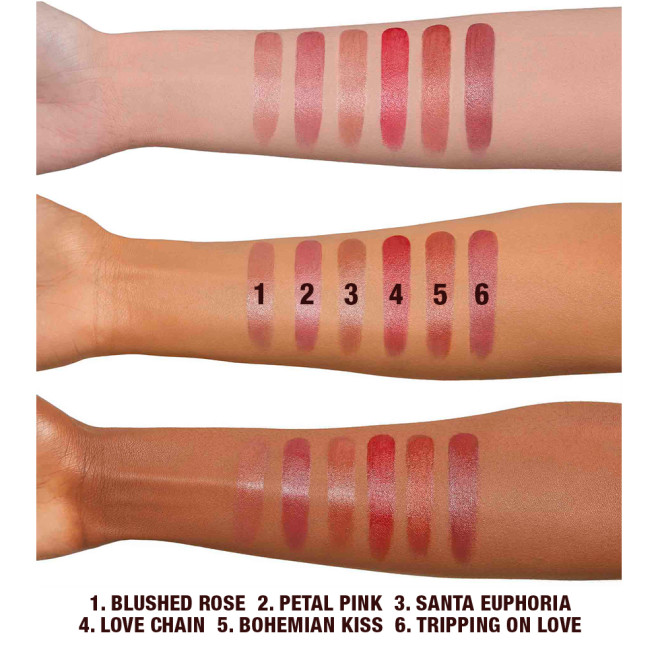 Swatches of six lip and cheek tints in shades of pink, red, brown, peach and purple on fair, tan, and deep-tone arms.