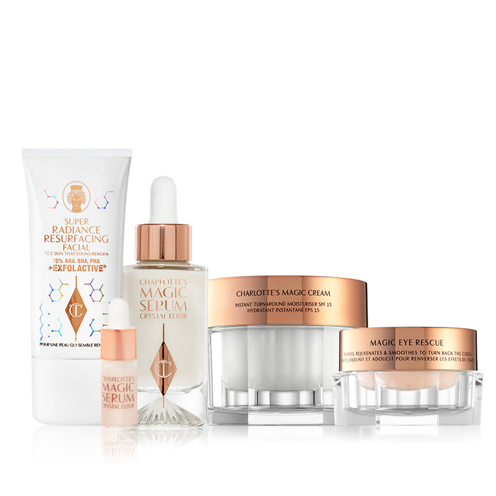 Charlottes Science Secrets Skincare Routine An exfoliating, wash-off, chemical mask in a white-coloured tube, luminous, ivory-coloured serum in a glass bottle with a white and gold dropper lid, pearly-white face cream in a glass jar with a gold-coloured lid, and fawn-coloured eye cream in a petite glass jar with a gold-coloured lid.