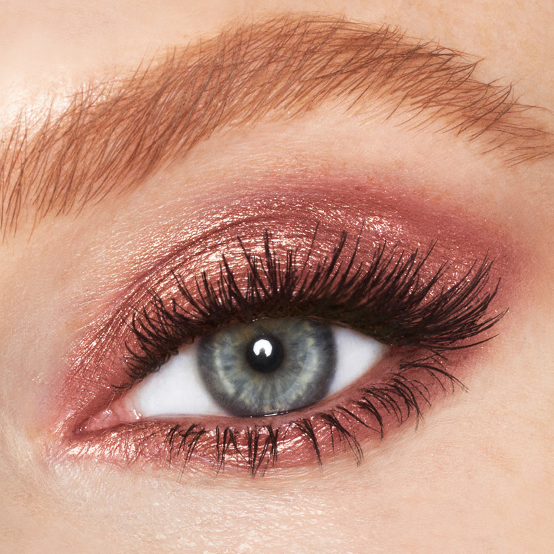 Close-up of a single blue eye with shimmery, rose-gold-coloured cream eyeshadow. 