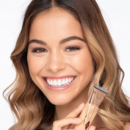 Beautiful Skin foundation in 7C on medium-light-tone model Medium-light-tone brunette model wearing glowy, skin-like foundation with a fresh, satin finish with a nude lipstick, and subtle eye makeup.