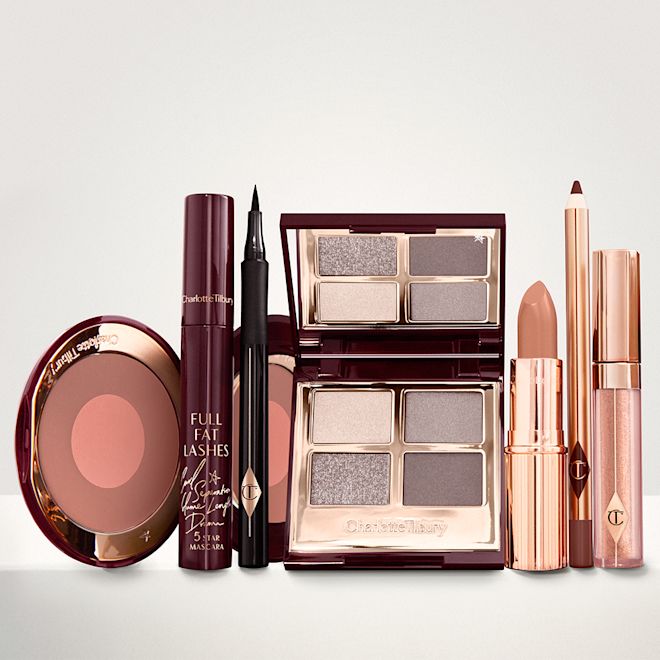 The Rock Chick Deep Look kit displayed An open two-tone blush in cool-toned brown and rose gold with a mascara, eyeliner pen, quad eyeshadow palette with shimmery and matte grey, beige and silver shades, an open lipstick in nude red, lip liner pencil in taupe-brown, and a lip gloss in nude pink.