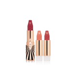 three, open, refillable lipsticks in berry-rose, nude peachy-pink, and warm orange-red in golden and black-coloured packaging.