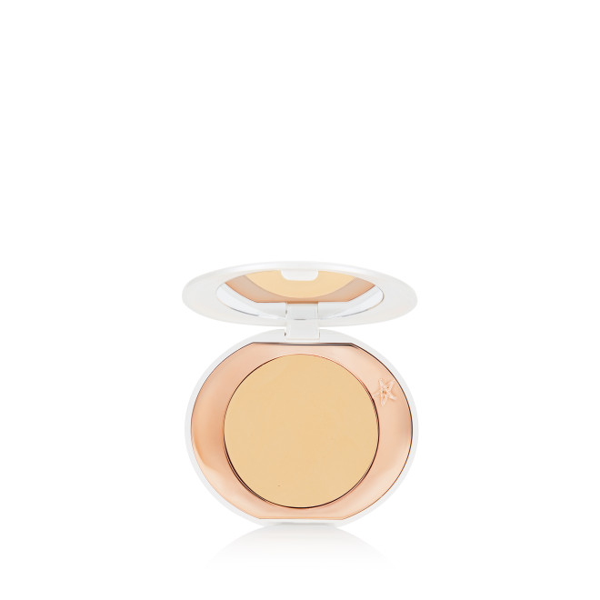 A miniature compact brightening powder in a white shade for tan and deep skin tones.