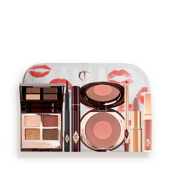 The Bella Sofia Deep kit with makeup pouch displayed A white makeup pouch with an open two-tone blush in cool-toned brown and warm pink with a mascara, eyeliner pen, quad eyeshadow palette with shimmery and matte brown and golden shades, an open lipstick in nude peach, lip liner pencil in taupe-brown, and a lip gloss in nude pink.