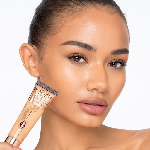 Beautiful Skin Foundation in 8W on deep-tone model Deep-tone model with glowy, flawless skin, wearing skin-like foundation that adds a youthful glow and looks natural along with nude pink lipstick and subtle everyday eye makeup.