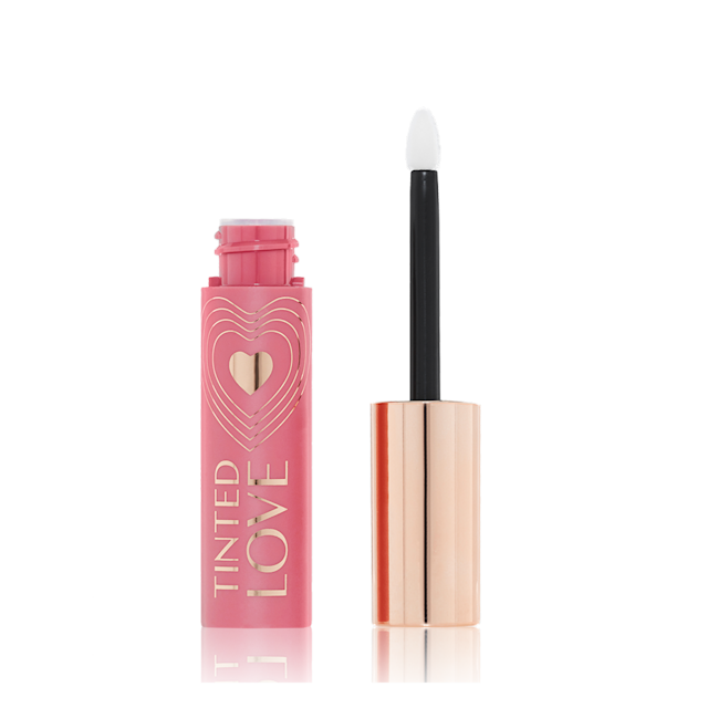 Tinted Love in Petal Pink open An open lip and cheek tint in a rosy pink shade with a pink-coloured bottle with a white and gold-coloured doe-foot applicator.