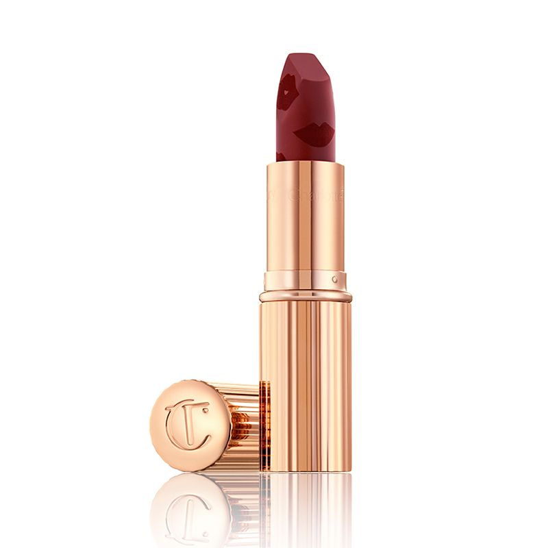 An open matte lipstick in a winter berry shade with metallic, golden-coloured packaging. 