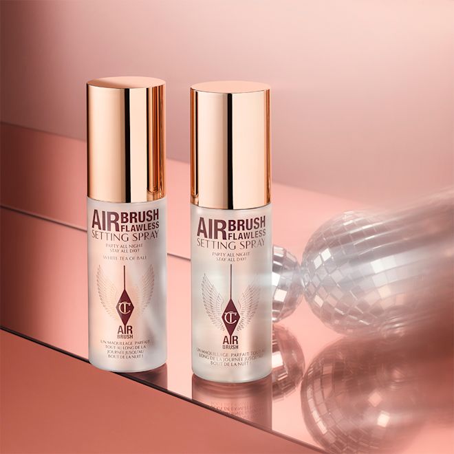 Airbrush Flawless Setting Spray Duo travel-size closed Two, identical, mini, setting sprays in clear bottles with gold-coloured lids.
