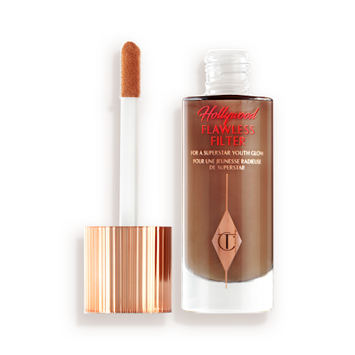 Hollywood Flawless Filter in shade 8 open An open, luminous primer in a dark brown shade in a glass bottle with its gold and white doe-foot applicator next to it.