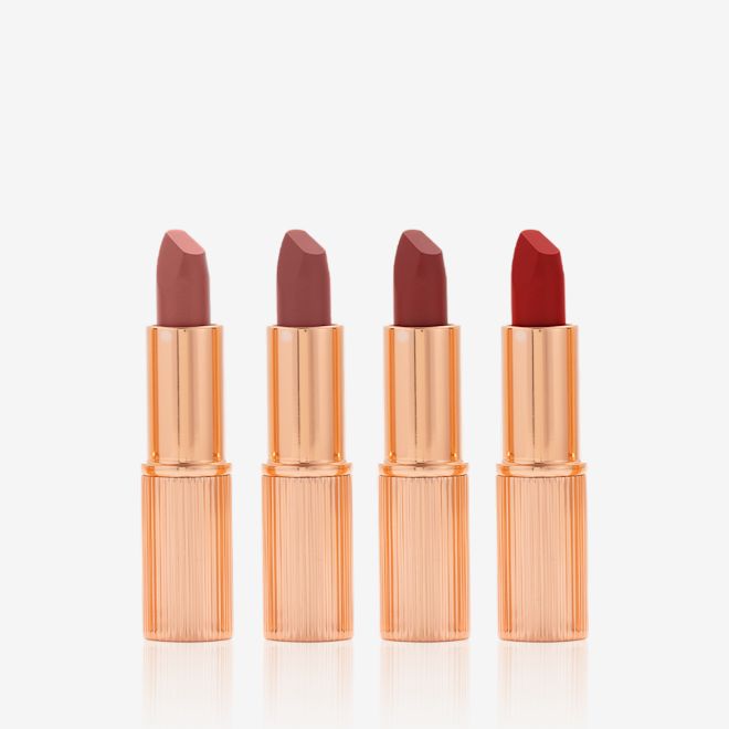Charlotte Tilbury's Magic Icons kit open Five matte lipsticks in nude shades of red and pink in sleek, gold-coloured tubes with their lids removed.